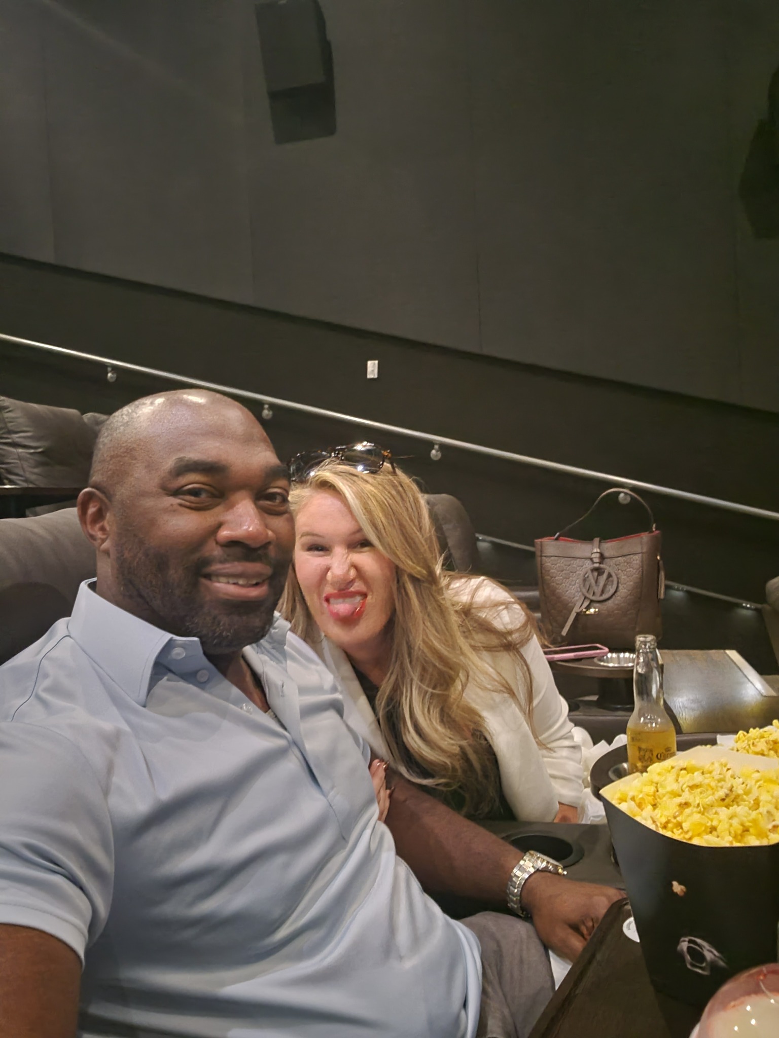 Drew and Sarah at the movies, with Sarah making a playful face beside a tub of popcorn